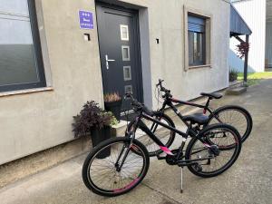 dos bicicletas están estacionadas fuera de una casa en Apartman Beli, en Vinkovci