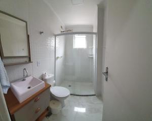 a bathroom with a shower and a toilet and a sink at Apto Aviação com Ar-Condicionado in Praia Grande