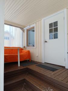 a room with a bed and a door on a deck at Aurinko in Varkaus