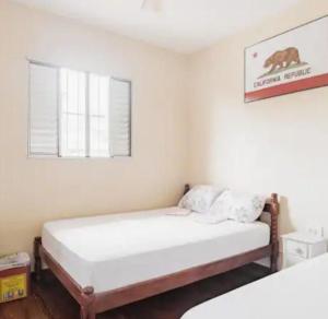 乌巴图巴Ubatuba Wild Surf Hostel的卧室配有两张床,墙上挂着熊的照片 更多37张照片