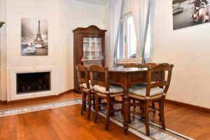 una sala da pranzo con tavolo, sedie e camino di Il Villino di Monic a Pisa