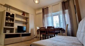 1 dormitorio con cama, mesa y TV en Holiday home Telese Roma, en Roma