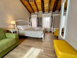 a bedroom with a bed and a green couch at Incantevole Casetta Veneziana in Venice