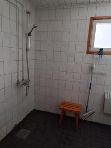 a bathroom with a shower and a wooden bench at Aurinko in Varkaus