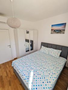 1 dormitorio con 1 cama con sábanas de lunares azules en Azure By The Beach, en Tivat