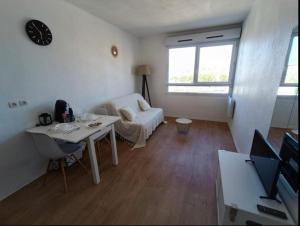 salon ze stołem i kanapą w obiekcie Appartement tout équipé à 6 minutes de la Gare St Charles w Marsylii