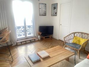 ein Wohnzimmer mit einem Couchtisch und einem TV in der Unterkunft Au pied de Montmartre in Paris