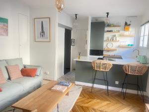 ein Wohnzimmer mit einem Sofa und einer Küche in der Unterkunft Au pied de Montmartre in Paris