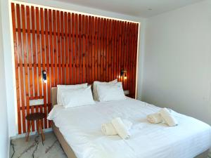 a bedroom with a large bed with two towels on it at Salonikiou Beach Apartments & Villas in Agios Nikolaos