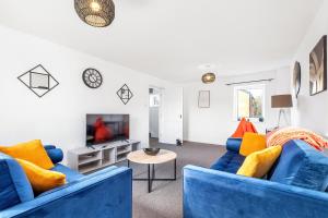 uma sala de estar com dois sofás azuis e uma televisão em Spacious house with 8 beds - convenient location - Whitwell em Peterborough