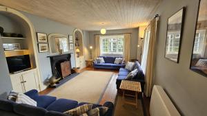 a living room with blue couches and a fireplace at Corner Cottage in Saint Mawes