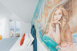 a bedroom with a painting of a woman on a wall at Albergo Dipinto BaccoFurore in Furore