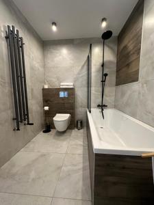 uma casa de banho com uma banheira, um WC e um lavatório. em Platinum em Budzyń