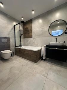 uma casa de banho com uma banheira, um WC e um lavatório. em Platinum em Budzyń