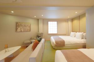 a hotel room with a bed and a couch at Senlax Inn Osaka in Osaka