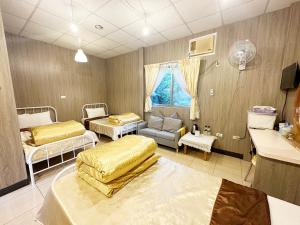 Habitación hospitalaria con 2 camas y sofá en 森霖旅宿, en Meinong