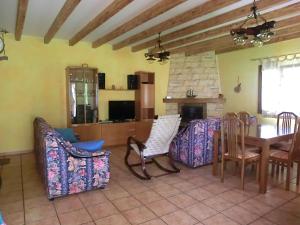 a living room with a table and chairs and a fireplace at El Establo,Casa rural in Busto de Bureba