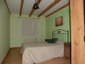 1 dormitorio con 1 cama en una habitación con paredes verdes en El Establo,Casa rural, 