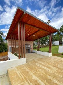 un gran pabellón de madera con chimenea en el patio en Hermosa Villa con piscina, en Los Santos