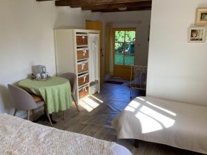a bedroom with a table and a room with two beds at La Grange in Nohant-Vic