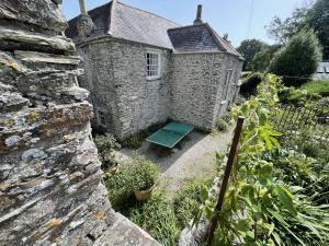 a stone house with a bench in a garden at Crugsillick Court in Veryan