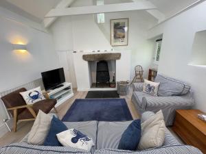 a living room with two couches and a fireplace at Crugsillick Studio in Veryan