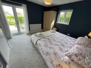 a bedroom with a bed and two windows at Crugsillick Studio in Veryan
