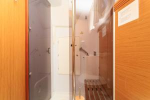 a glass shower in a bathroom with a tub at Salis - Jeanneau 39i in Lisbon