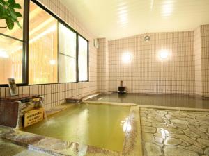 an empty pool of water in a room with a window at Hotel Yume-no-yu in Omachi