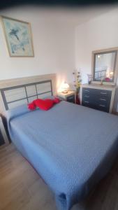 Una cama azul con almohadas rojas en un dormitorio en Villa Delfín, en Calafell