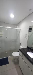 a bathroom with a toilet and a sink and a mirror at Apartamentos Ed London, na Av principal a poucos passos das Termas in Piratuba