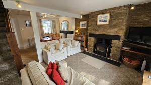 un soggiorno con divano e camino di Hillside Cottage a Porthscatho