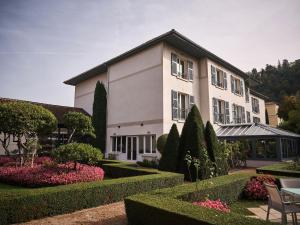 un gran edificio blanco con un jardín delante de él en La Pyramide - Maison Henriroux, en Vienne