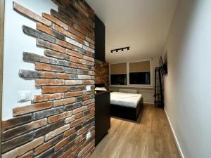 uma parede de tijolos numa sala com um quarto em No. 2 Comfy center apartment em Klaipėda