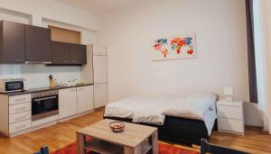 uma cozinha com uma cama e uma mesa num quarto em Flarent Economy Apartments em Viena