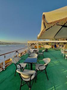 um grupo de mesas e cadeiras no convés de um navio em Luxor Aswan Victoria Nile Cruise every Saturday from Luxor 4 nights & every Wednesday from Aswan 3 nights em Luxor