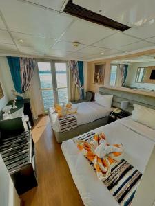 a large room with two beds and a couch at Luxor Aswan Victoria Nile Cruise every Saturday from Luxor 4 nights & every Wednesday from Aswan 3 nights in Luxor
