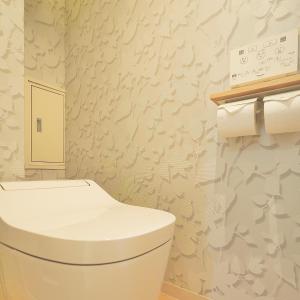 ein Badezimmer mit einer weißen Toilette und Blumen an der Wand in der Unterkunft Senlax Inn Osaka in Osaka + 39 Fotos