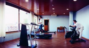 two men exercising on exercise bikes in a gym at Hotel Terra in Padrón