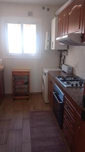 a kitchen with wooden cabinets and a stove top oven at Villa Delfín in Calafell