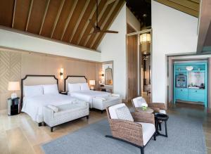 a hotel room with two beds and chairs at Waldorf Astoria Maldives Ithaafushi in South Male Atoll +37 photos