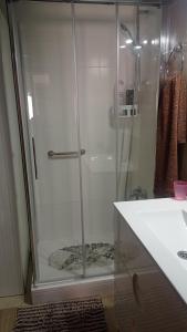 una ducha con una puerta de cristal junto a un lavabo en Villa Delfín, en Calafell