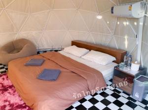 1 dormitorio con 1 cama con 2 toallas en รักไทยโฮมสเตย์ en Ban Rak Thai