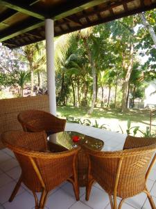 una mesa y sillas en un porche con árboles en Argasoka Bungalows, en Ubud