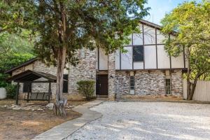 une maison en briques avec un arbre devant elle dans l'établissement Pool, Gameroom & Minigolf Enchanting Texas Home, à San Antonio