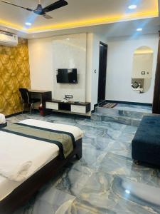 Habitación con cama, TV y sofá. en Hotel Stay Well Pithampur en Akolia