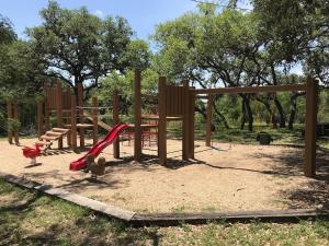 a playground with a slide and a swing set at Pool, Gameroom & Minigolf Enchanting Texas Home in San Antonio
