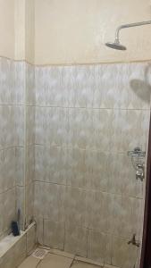 a bathroom with a shower with a tiled wall at Zuhura homes in Ruiru