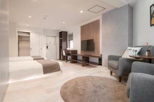 ein Schlafzimmer mit Bett, Schreibtisch und Fernseher in der Unterkunft Senlax Inn Osaka in Osaka