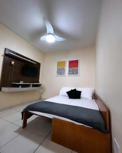 a bedroom with a bed and a ceiling fan at Pérola de Santos House in Santos